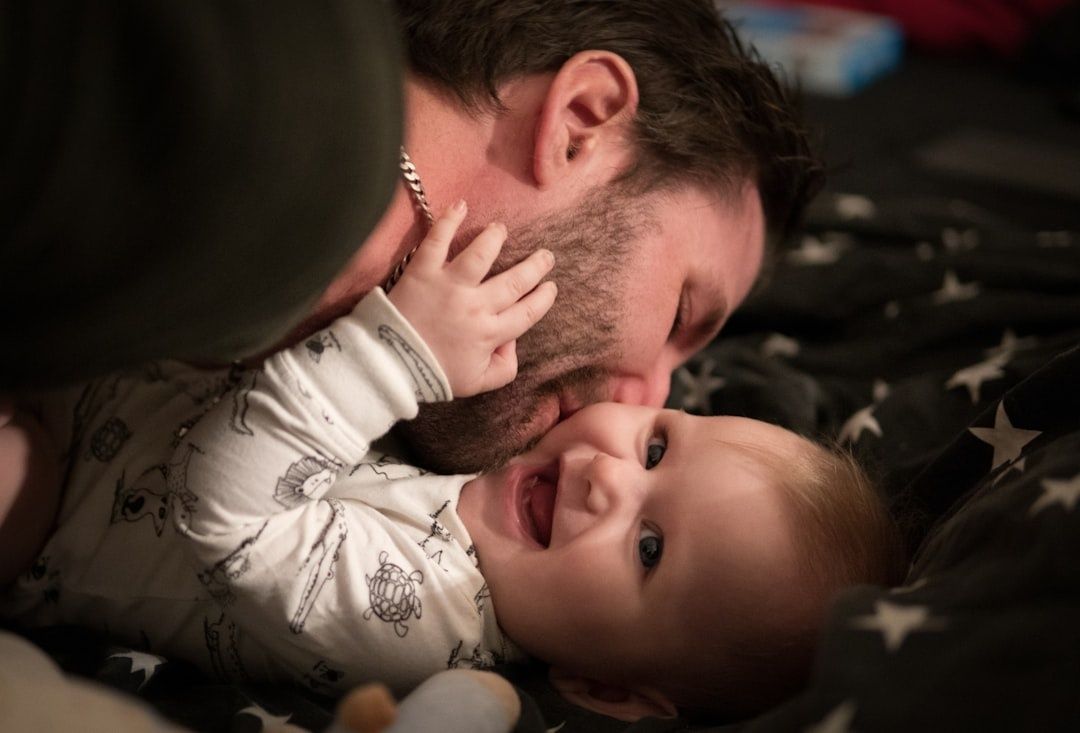 Vader knuffelt lachende baby op een bed