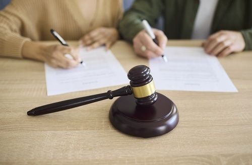 Houten rechtershamer voor ouders die juridische documenten ondertekenen