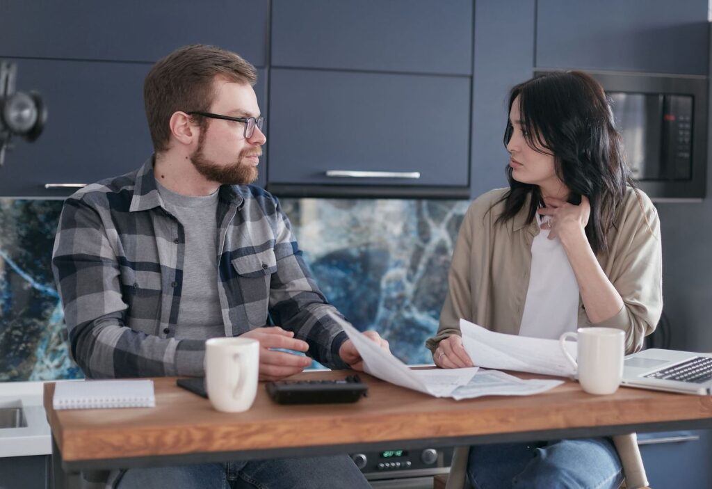 Stel bespreekt financiële documenten aan de keukentafel