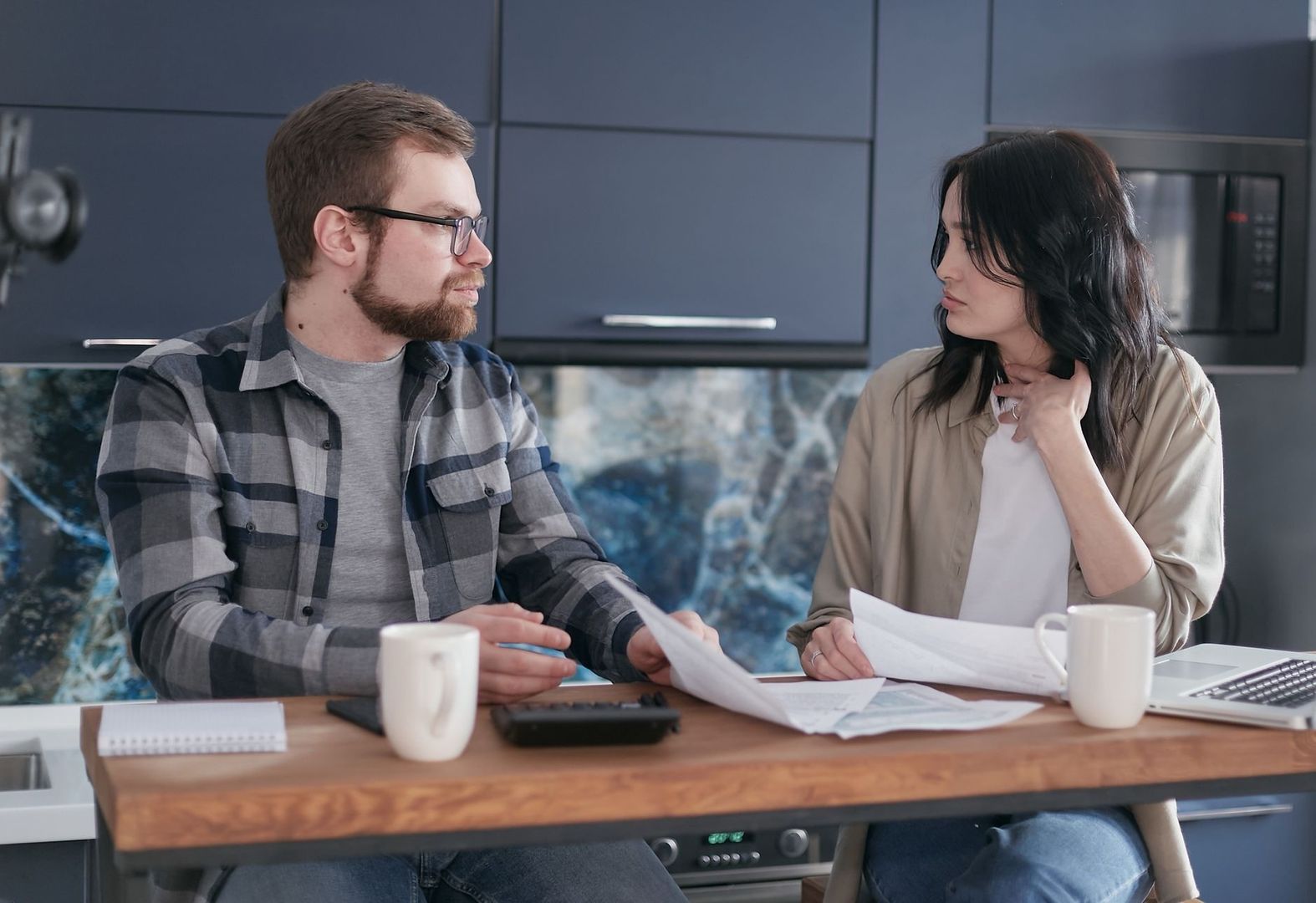Stel bespreekt financiële documenten aan de keukentafel
